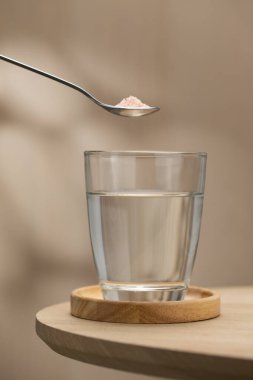 Bir bardak içme suyuna bir kaşık Himalaya tuzu eklenerek, potansiyel sağlık faydaları vurgulanıyor..