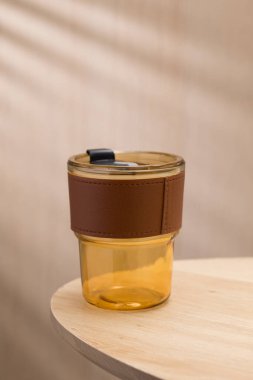 Kahverengi deri kollu kehribar cam bardak bardak, zarafet ve işlevselliği birleştirerek modern yaşam tarzları için mükemmel bir seçim yapıyor..