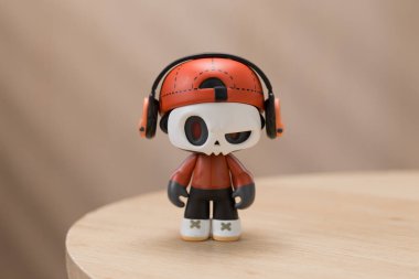 Bu figür, kulaklık ve keple vurgulanmış, benzersiz bir kafatası yüzlü karakter sergiliyor..