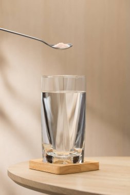 Bir bardak içme suyuna bir kaşık Himalaya tuzu eklenerek, potansiyel sağlık faydaları vurgulanıyor..