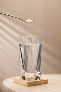 Bir bardak içme suyuna bir kaşık Himalaya tuzu eklenerek, potansiyel sağlık faydaları vurgulanıyor..