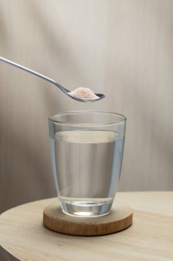 Bir bardak içme suyuna bir kaşık Himalaya tuzu eklenerek, potansiyel sağlık faydaları vurgulanıyor.
