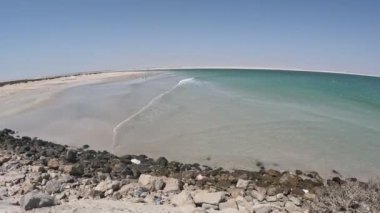 Hafif dalgaların hareketli çekimi kayalık kıyılarda tur atar, Duqum 'daki Bantoot Sahili' nin el değmemiş altın kumları ve canlı turkuaz sularıyla karşılaşır.