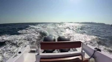 Hız yapan bir teknenin arkasından dinamik bir manzara, parlak bir güneşin altında köpüklü izler bırakmak, Muscat, Umman 'daki Mina Al Fahal' da maceranın heyecanını uyandırmak,.