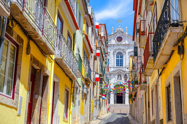 Old town street decorated by flags . Colorful street with residential houses in Lisbon Portugal 