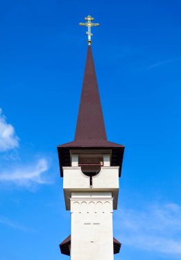 Kilise tepesinde haç olan bir kule gibi. Mavi gökyüzüne karşı çan sesi 
