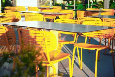 Sokak şehir terası. Sarı sandalyeler ve masalar