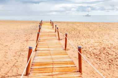 Kumsala giden yol. Yürüme yolu olan kumlu sahil 