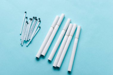 Sigaralar ve Kibritler Mavi Arkaplanda. Tütün ürünleri