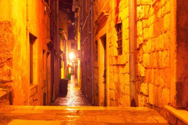 Eski şehrin aydınlık dar sokağında. Geceleyin Dubrovnik 'in sokak aydınlanması