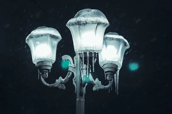 Snowfall over street lamps . Night snowfall and street light
