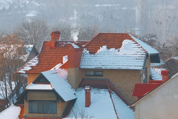Cottage With Snowy Roof in Winter . Tiled roof with snow
