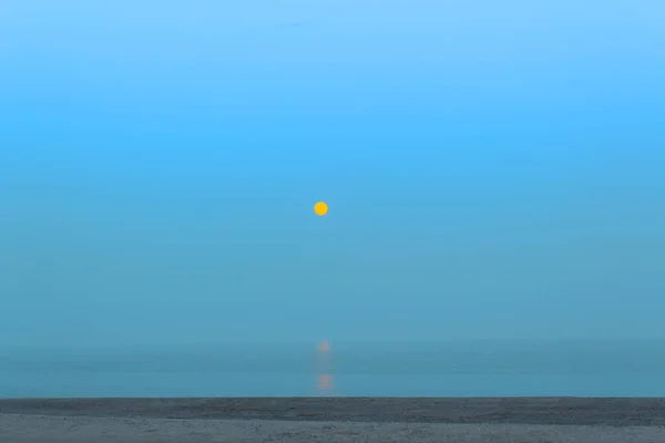 Moon over the sea in the morning . Moon reflection in the sea water