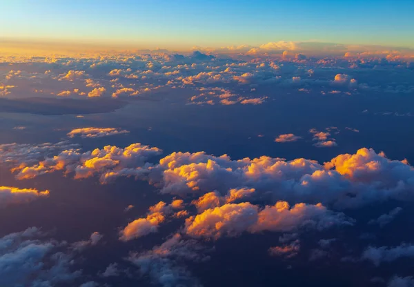 Flying over fantastic clouds in the evening . Spectacular aerial view of clouds over the ocean