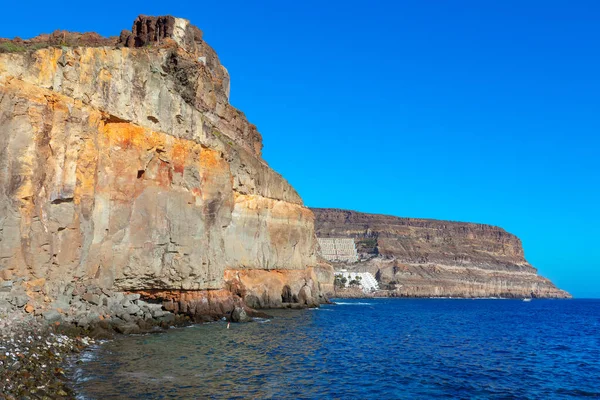 Taurito Plajı ve Gran Canaria 'daki tatil köyü. Kanarya Adalarının Rocky kıyı dağları