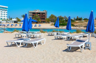 Kıbrıs 'taki Ayia Napa Plajı' nda yaz tatili. Kumsaldaki güverte salonları