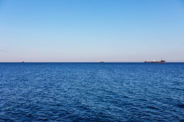 Denizin panoramik manzarası ve uzaktaki gemi. Tekneli mavi deniz ufku