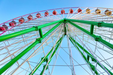 Mavi gökyüzü arka planında dönme dolap. Eğlence parkı gezisi