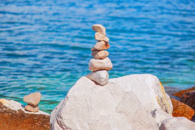 Denizin arka planında taş piramit. Uyum ve denge kavramı