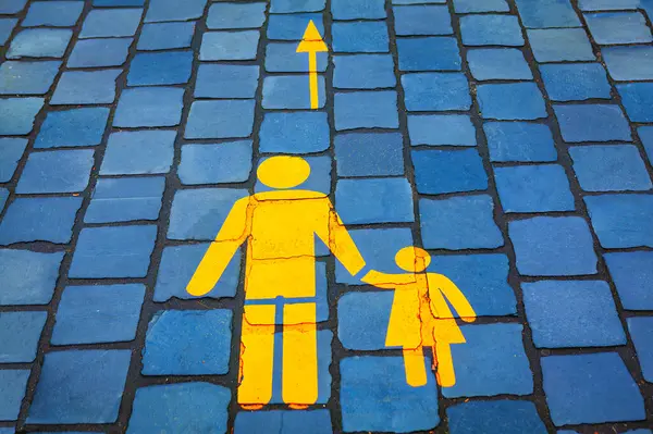 Pedestrian walkway with yellow family symbol . Yellow family painted on the pavement in the park
