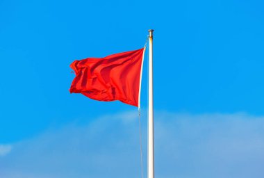  Mavi gökyüzünde kırmızı bayrak sallıyor