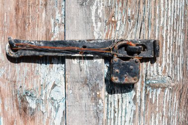 Eski paslı menteşe yıpranmış ahşap bir kapının üzerinde. Sığ alan derinliği