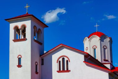 Kırmızı ve beyaz kilise bulutlu mavi gökyüzüne karşı. Dini mimari