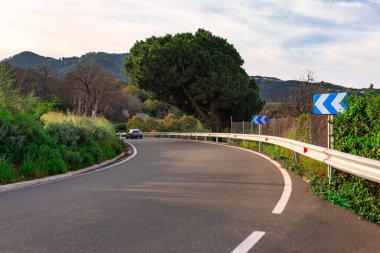 Güneşli bir günde, mavi gökyüzü ile dağlarda asfalt yol