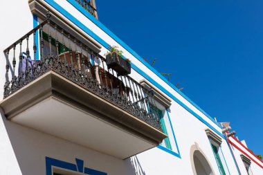 Balkon, el değmemiş beyaz bir evin kenarına bağlıdır. Gökyüzü ve mimari arasında bir kontrastlık sunar.