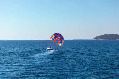 Yaz tatilinde mavi denizde paraşütle atlamak. Yaz su sporları 