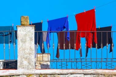 Güneşli bir günde çatıda kuruyan giysiler. 