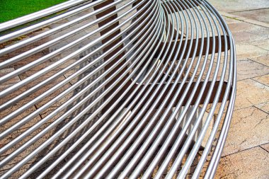 Arka planda kaldırım olan parktaki metal bank