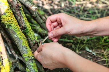 Kamp ateşi yakmak için elleri kibrit yakıyor