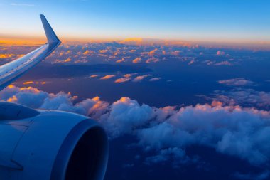 Uçak motoru ve kanatları akşam boyunca bulutların üzerinde zarifçe süzülür. Atlantik Okyanusu 'ndaki Kanarya Adaları üzerinde uçmak 