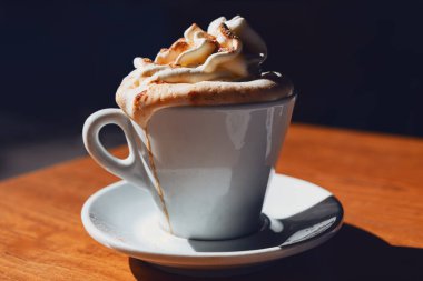 Üstünde krema olan bir fincan kahve. Günaydın sıcak, lezzetli içecek. 