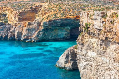 Malta 'daki Comino adasında turkuaz sular ve kayalık kıyı oluşumları yer almaktadır.