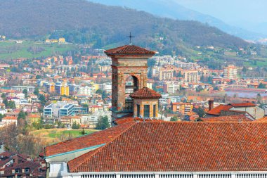 Kilise kulesi ve kiremitli çatıları olan şehir silueti. Bergamo, Lombardy, İtalya 'nın panoramik manzarası