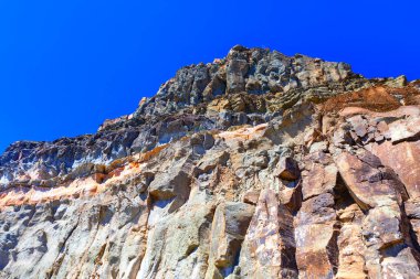 Manzaralı bir yerde devasa bir kaya oluşumu. Mavi gökyüzüne karşı kayalık