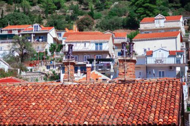 Kırmızı çatısı ve beyaz süslemesi olan evler. Evlerin hepsi farklı boyutlarda ve tarzlarda. Çatıyı kaplayan parlak kırmızı fayanslar