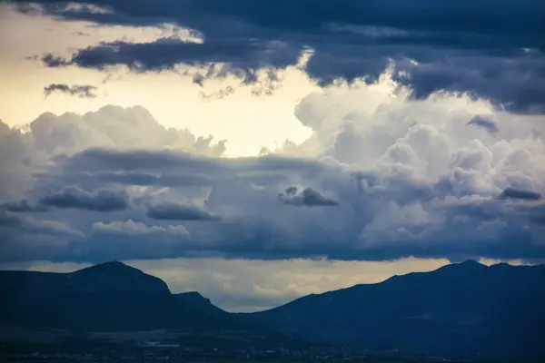 stock image Evening sky is cloudy and the mountains are in the background. Scene is somewhat ominous and foreboding