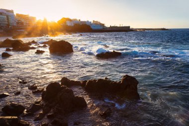 Tenerife, Kanarya Adaları 'ndan Puerto de la Cruz' da gün batımı. Okyanus dalgalarını kıran kayalar