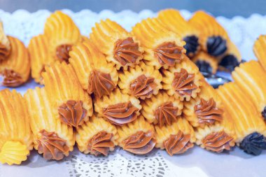 Bir tabak taze kızarmış churro. Üstünde çikolata sosu olan bir yığın browni. Şekerlemeler kalın ve kremalı. Browniler de altın sarısı. Yığın yığınla yüksek, bolluk ve hoşgörü hissi yaratıyor.