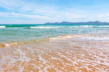 İspanya 'nın Mallorca adasının kuzey kıyısındaki Alcudia körfezi. Kumsal dalgalarla dolu. 