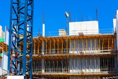 İnşaat alanında vinç ve iskele var. İnşaat vinci inşaat alanında çalışıyor