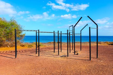 Plajda metal parmaklıkları olan bir park. Açık hava sporu için