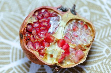 Kırmızı nar ikiye bölünür ve tohumları ortaya çıkar. Meyve olgun ve sulu, beyaz masa örtüsüyle zıt parlak kırmızı bir renk ile