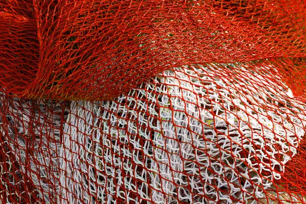 Kalıplı yüzeyi olan kırmızı balık ağı. Beyaz çizgili kırmızı ve beyaz ağ.