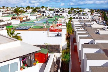 Playa Blanca Lanzarote 'nin yerleşim bölgesi, Kanarya adaları. Sahildeki hareketli şehrin panoramik manzarası sayısız binayla dolu.