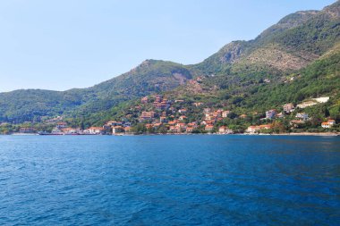 Karadağ 'ın arka planında küçük bir kasabası olan Kotor Körfezi. Lepetani Karadağ 'ın Tivat belediyesine bağlı bir köydür.