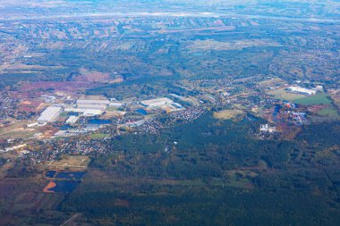 Geniş bir orman. Etrafı uzak şekillerle çevrili. Uçak penceresinden kasaba manzarası